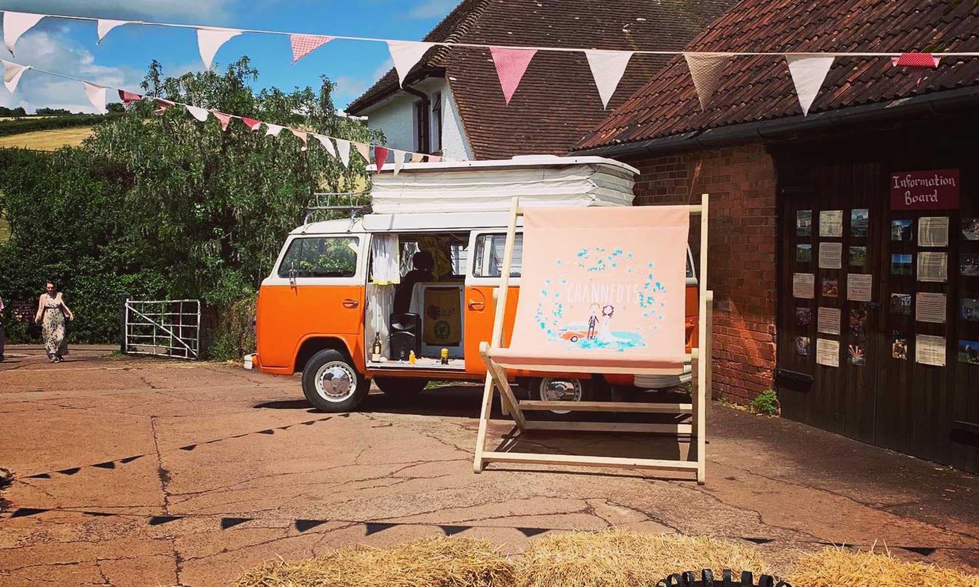 Giant deckchair at a rustic wedding venue with vintage VW campervan